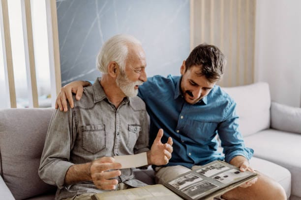 Accueil 9 Père et fils regardant un album photo de famille - transmission mémorielle